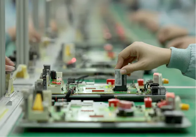 A hand precisely placing an electronic component onto a circuit board